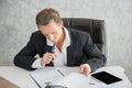 Businessman sitting at his workplace in front of laptop computer while doing some business Royalty Free Stock Photo