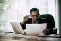 Businessman sitting at his workplace in front of laptop computer while doing some business Royalty Free Stock Photo