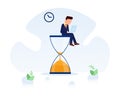 Businessman sitting on the hourglass with laptop legs crossed. Business concept of time management and procrastination.