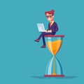 Businessman sitting on the hourglass with laptop legs crossed. Business concept of time management and procrastination.