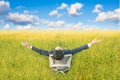 Businessman sitting on office armchair and open arm in yellow flower field Royalty Free Stock Photo