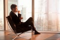 Businessman sitting in office chair enjoying coffee in the morni Royalty Free Stock Photo