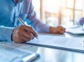 Businessman sitting at office desk signing a contract close up