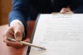 Businessman sitting at office desk signing a contract with shallow focus on signature Royalty Free Stock Photo