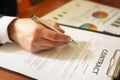 Businessman sitting at office desk signing a contract with shallow focus on signature Royalty Free Stock Photo