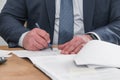 Businessman sitting at office desk signing contract with shallow focus on signature. Head of company sign contract Royalty Free Stock Photo