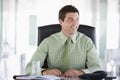 Businessman sitting in office with personal organi