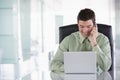 Businessman sitting in office using cellular phone