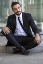 Businessman sitting outside on the curb and waiting Royalty Free Stock Photo