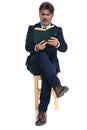 Businessman sitting and reading a book intrigued