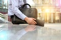 Businessman sitting / resting after working day and holding a leather briefcase in his hand Royalty Free Stock Photo