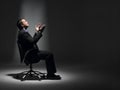 Businessman Sitting In Spotlight Royalty Free Stock Photo