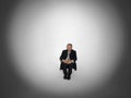 Businessman Sitting In Spotlight Royalty Free Stock Photo