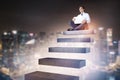 Businessman sitting on stairs in night city sky