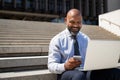 Businessman sitting on stairs and working on laptop Royalty Free Stock Photo