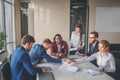 Businessman sitting at table with working blurred people on background. Royalty Free Stock Photo