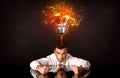 Businessman sitting under a blowing idea bulb Royalty Free Stock Photo