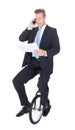 Businessman Sitting On Unicycle Talking On Cellphone