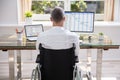 Businessman sitting on wheelchair and using computer