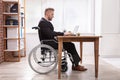 Businessman Sitting On Wheelchair Using Laptop Royalty Free Stock Photo