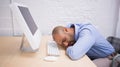 Businessman sleeping by computer at desk Royalty Free Stock Photo