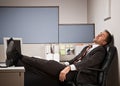 Businessman sleeping at desk with feet up Royalty Free Stock Photo