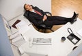 Businessman sleeping at desk with feet up Royalty Free Stock Photo