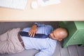 Businessman sleeping under desk Royalty Free Stock Photo