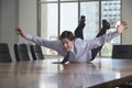 Businessman Sliding On Conference Table Royalty Free Stock Photo