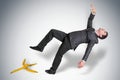 Businessman slipping and falling from a banana peel Royalty Free Stock Photo