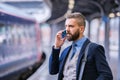 Businessman with smartphone, making a phone call, train platform Royalty Free Stock Photo