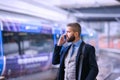 Businessman with smartphone, making a phone call, train platform Royalty Free Stock Photo