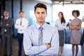 Businessman smiling at camera while her colleagues standing in background Royalty Free Stock Photo