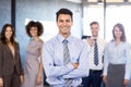 Businessman smiling at camera while his colleagues posing in background Royalty Free Stock Photo