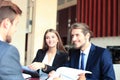 Businessman smiling happily as his business partner finally signing important contract. Royalty Free Stock Photo