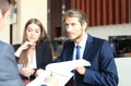 Businessman smiling happily as his business partner finally signing important contract. Royalty Free Stock Photo