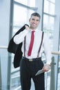 Businessman smiling and looking at camera with jacket over shoulder Royalty Free Stock Photo