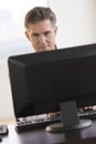 Businessman Smiling While Looking At Computer Monitor