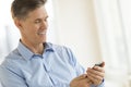 Businessman Smiling While Messaging Through Mobile Phone Royalty Free Stock Photo