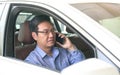 Businessman smiling and talking on his cell phone inside his car Royalty Free Stock Photo