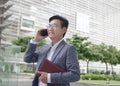 Businessman smiling and talking on the phone.while holding a diary Royalty Free Stock Photo