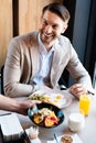 Businessman smiling while waiter putting dish on table Royalty Free Stock Photo