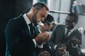 Businessman smoking cigar with multicultural business team