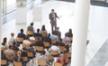 Businessman speaking in front of business people while holding digital tablet and microphone at conf Royalty Free Stock Photo