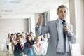 Businessman speaking through microphone during seminar in convention center Royalty Free Stock Photo