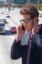 Businessman Speaking On Mobile Phone By Noisy Freeway Royalty Free Stock Photo