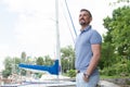 Businessman spending time walking on marina and looking sightseeing at vacation. Portrait of young happy yachtsman