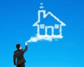 Businessman spraying house shape cloud paint with blue sky Royalty Free Stock Photo