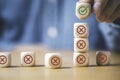 Businessman stacking green correct sign mark on top of Red Cross mark which print screen on wooden cube block for approve and