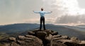 Businessman stand on peak mount with flutters on wind